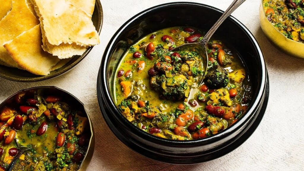 Ingredients for Ghormeh Sabzi with chicken including herbs, chicken, beans, and dried limes