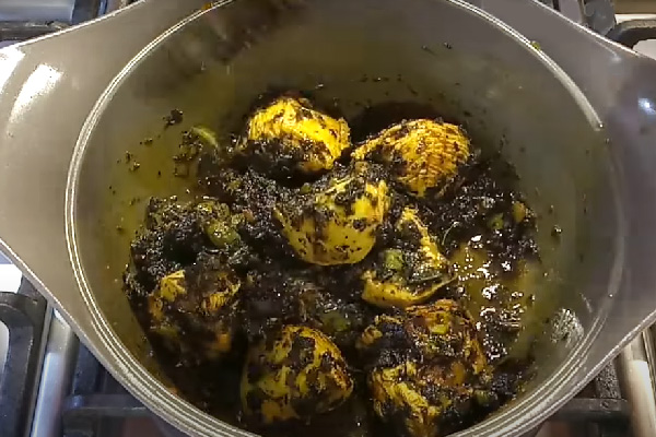 Sautéing Ghormeh Sabzi herbs in a pan for chicken stew